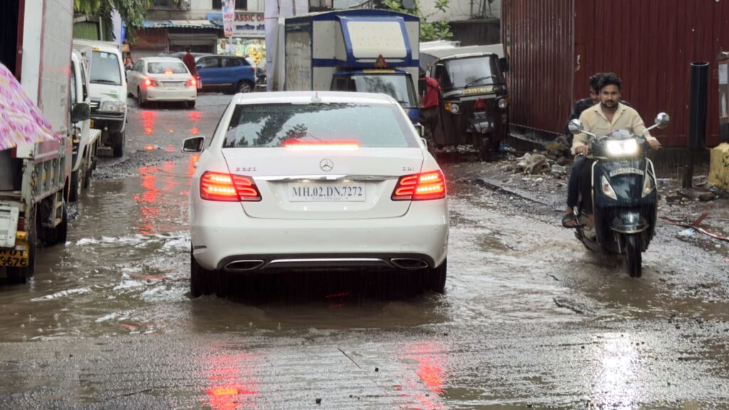 Car driving through heavy monsoon rain on a wet Indian road