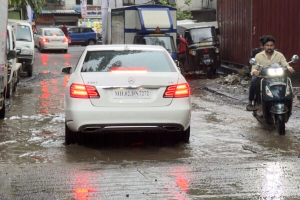 Car driving through heavy monsoon rain on a wet Indian road