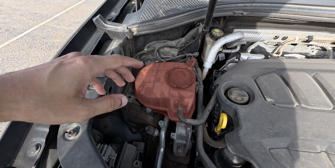 Coolant expansion tank showing the level between MIN and MAX marks