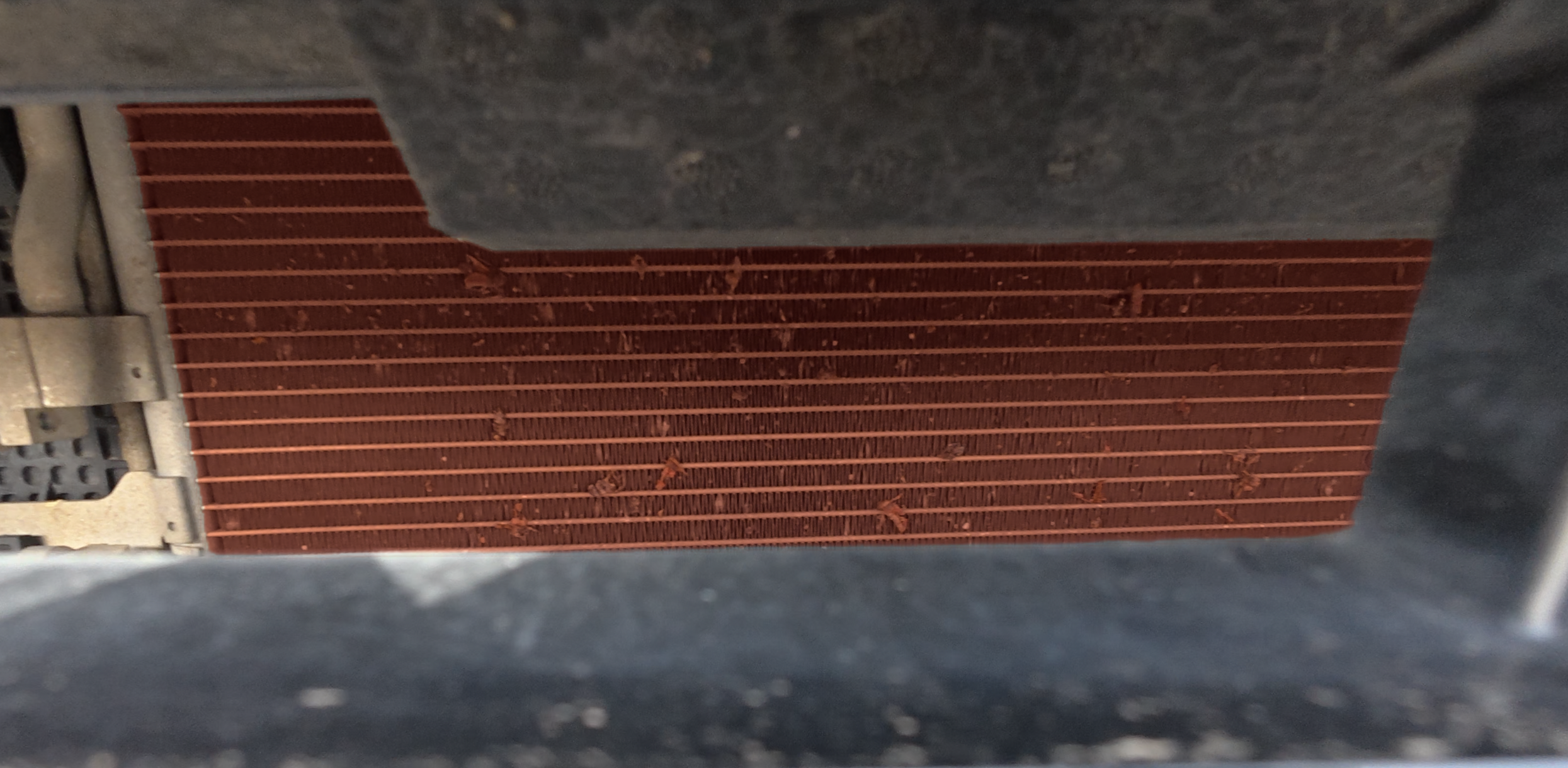 Close-up of a new car's radiator grille and condenser fins during PDI